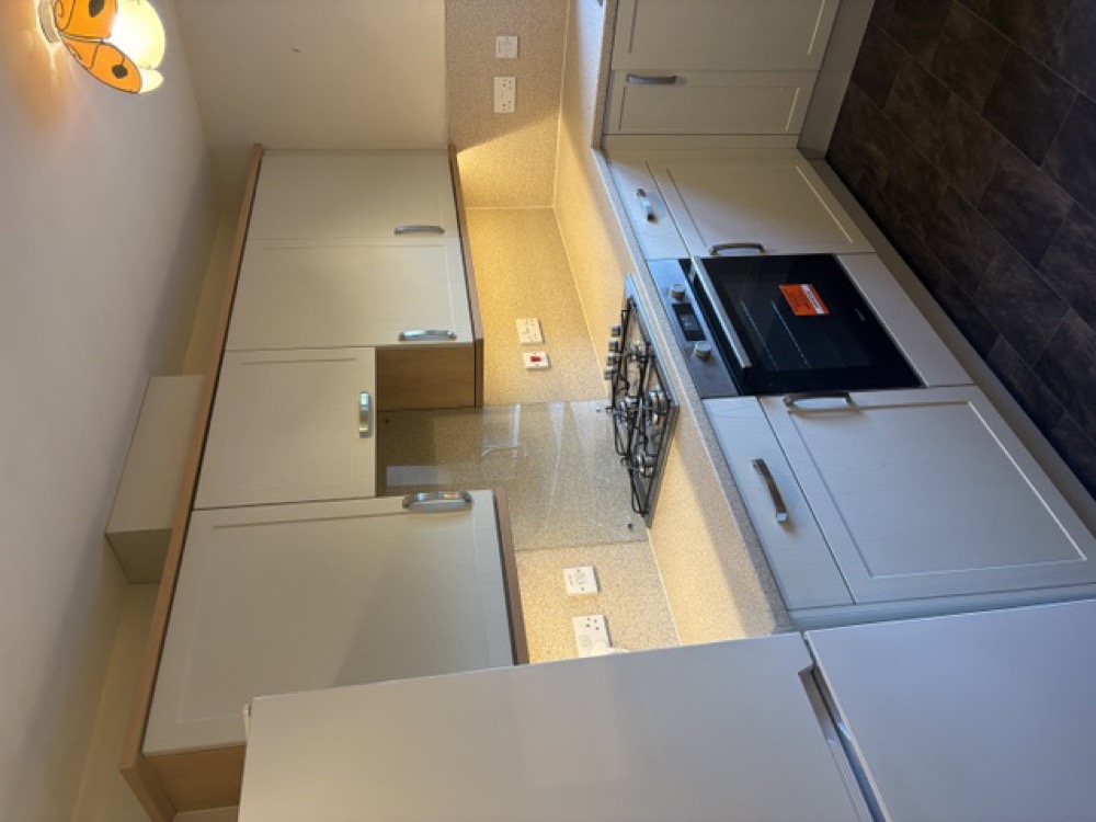 The same Malvern kitchen after: cream shaker doors and a light stone worktop