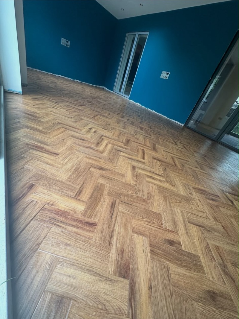 Dark herringbone flooring in an open-plan kitchen