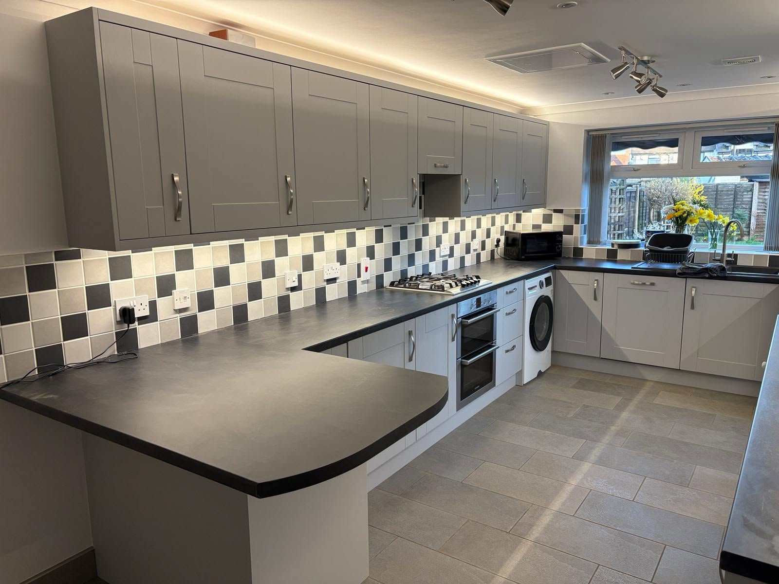 A finished kitchen makeover in a soft blue shaker style with brass handles